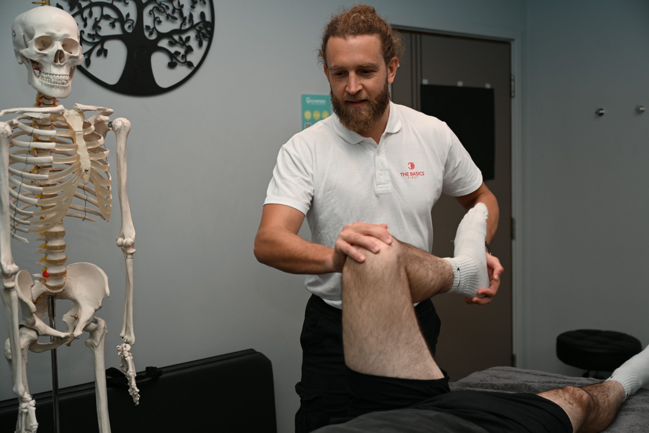 Osteopath assessing movement and posture during a home visit
